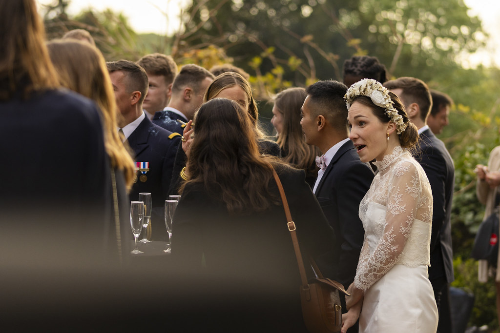 La mariée en dentelle parmi ses invités, au soleil couchant