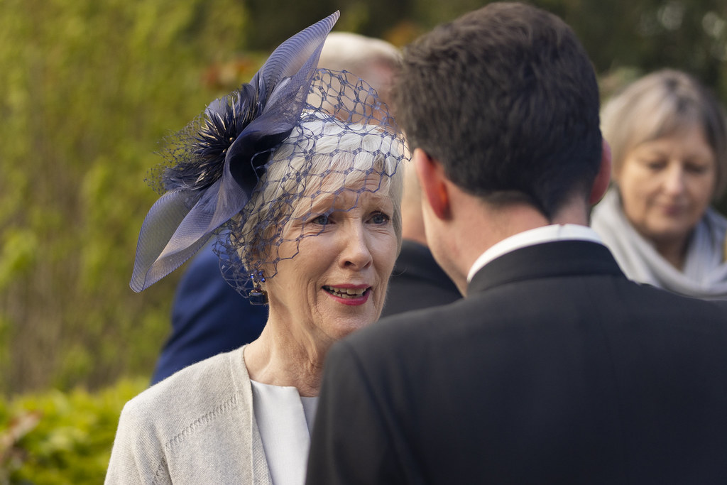 Une invitée à la voilette bleue en pleine conversation