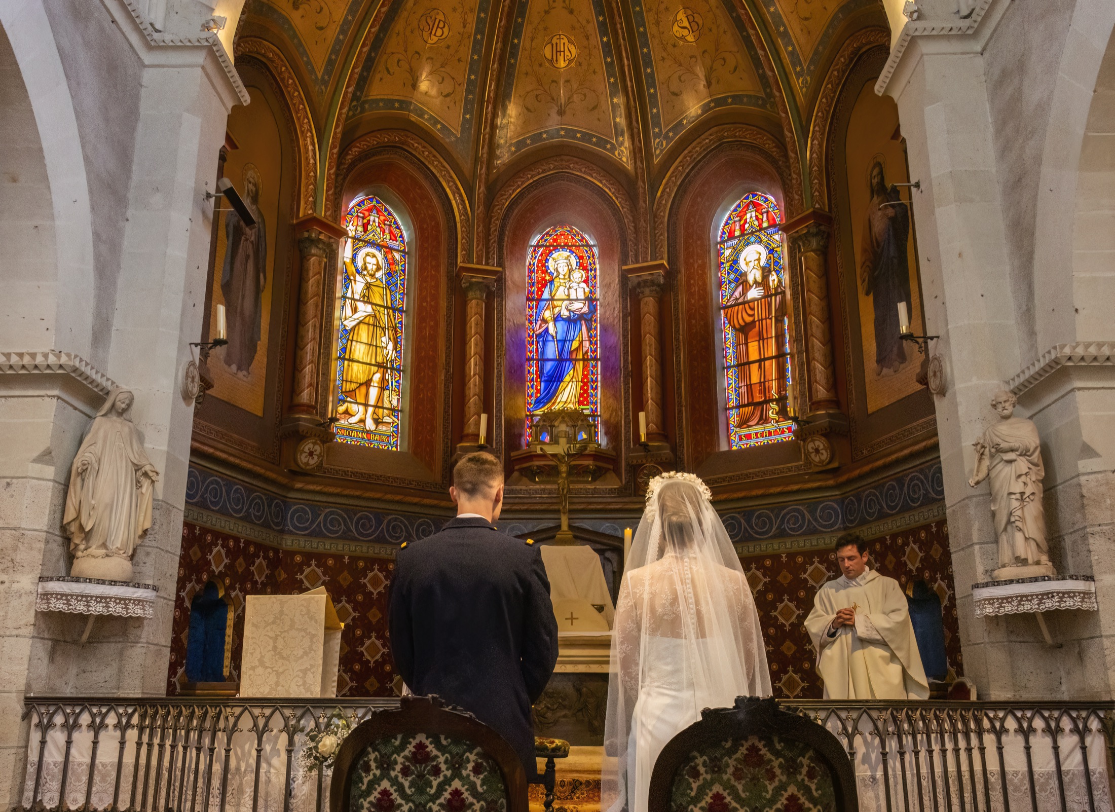 Les mariés devant l'autel sous les vitraux