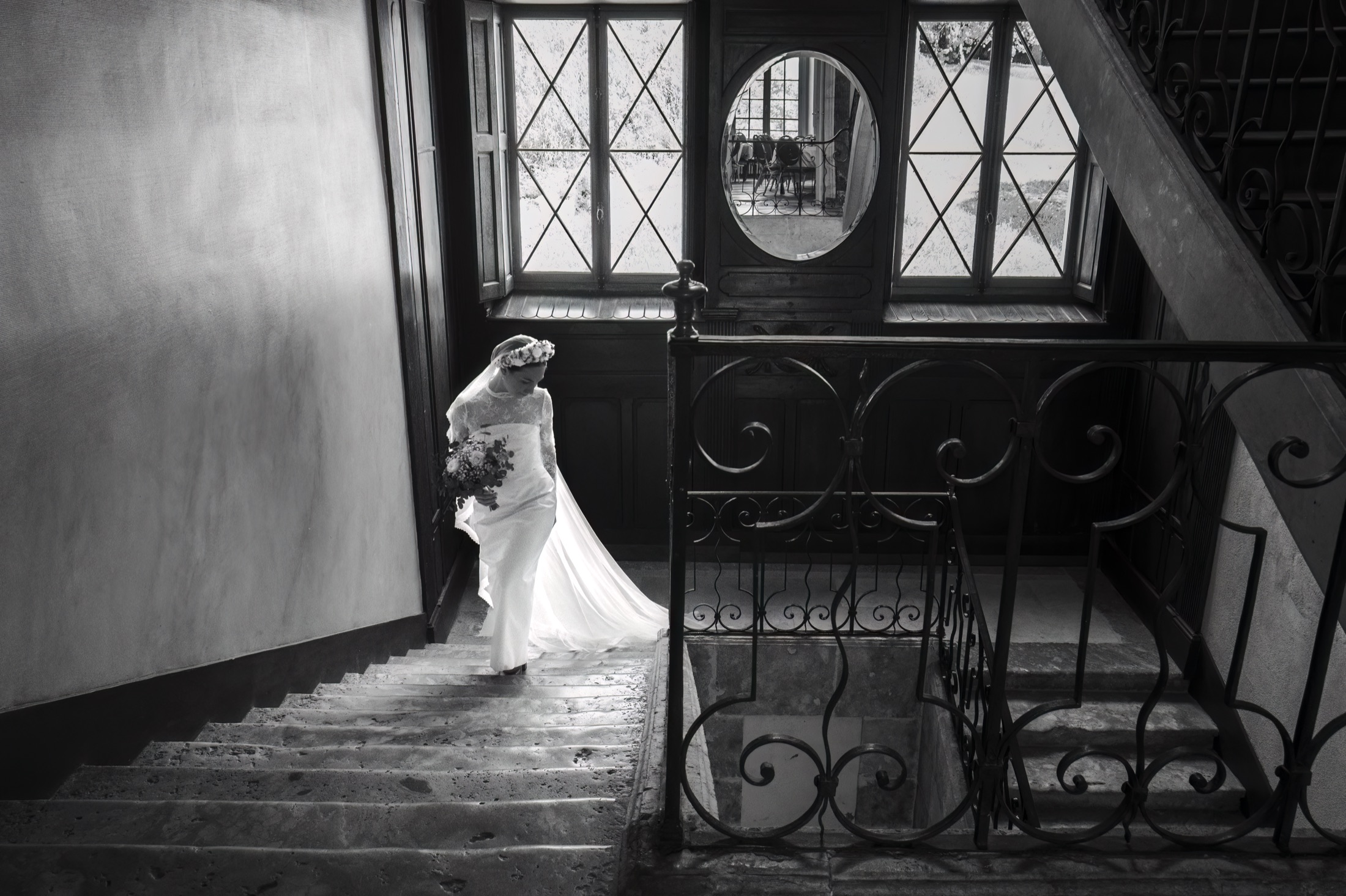 La mariée gravit un escalier de pierre, noir et blanc